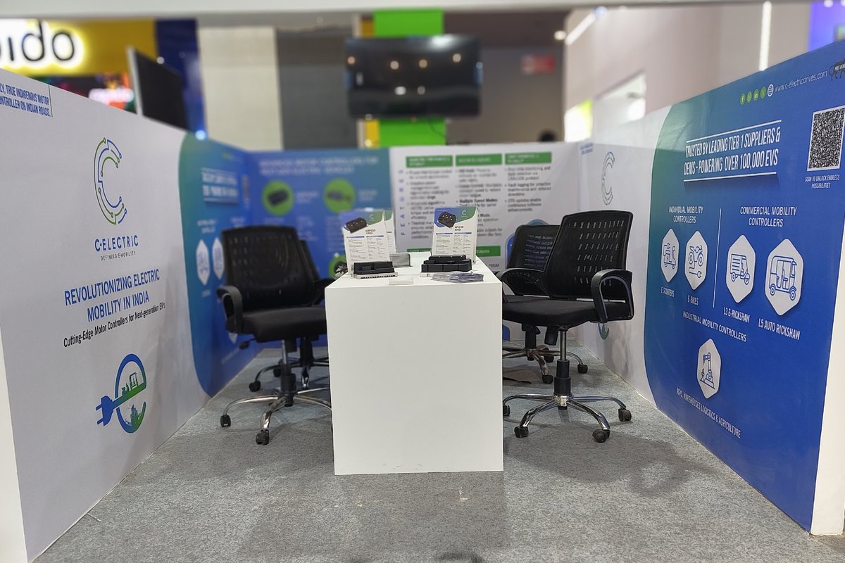 The C-Electric stand at Bharat Mobility Global Expo 2025, with controllers on the table and panels showing the product range